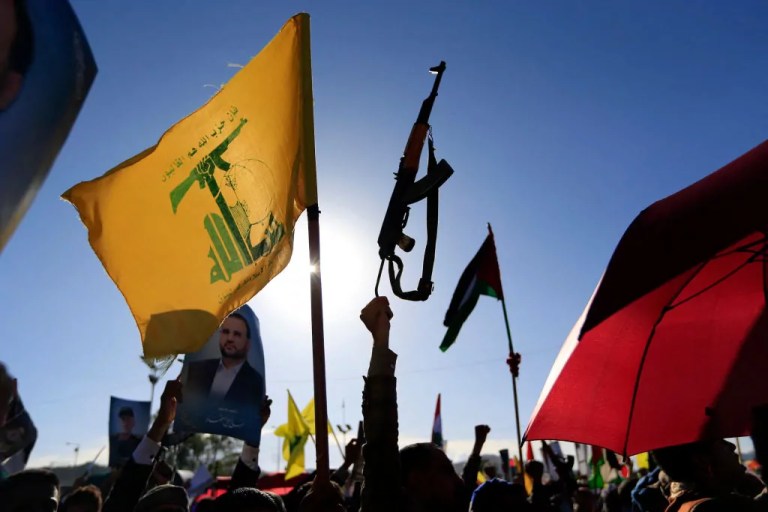 Yemenis raise a Lebanese Hezbollah flag and a rifle during a rally held in the Huthi-controlled capital Sanaa on Oct. 4, 2024, in protest against Israel's attacks on Lebanon and the ongoing war between Israel and Hamas militants in the Gaza Strip. The U.S. military said on Oct. 4 that it struck 15 targets in areas of Yemen controlled by Huthi rebels, who have fired missiles at Israel and repeatedly attacked global shipping in the Red Sea.