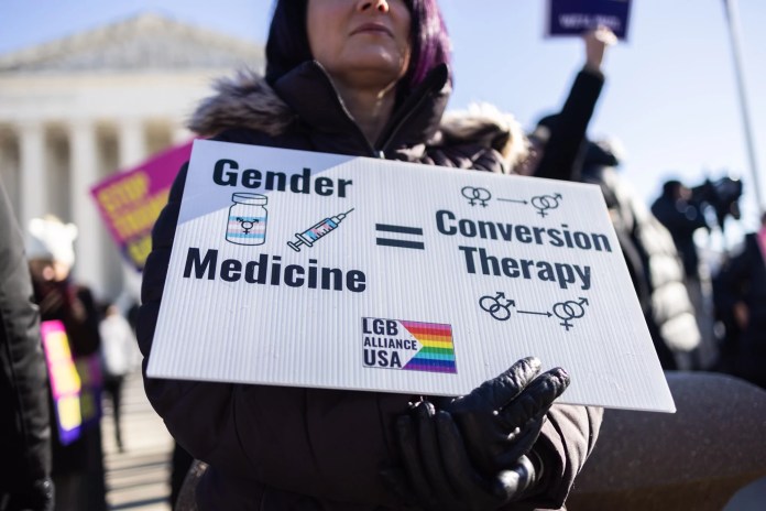 Demonstrators against transgender rights protest during a rally outside of the Supreme Court.