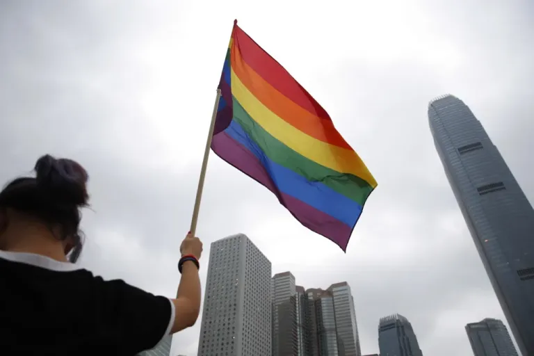 A participant holds a rainbow flag.