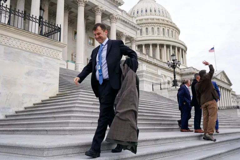 Tom Kean removes his coat as he arrives for a class photo of newly-elected members of Congress on the East Front of the Capitol in Washington, Tuesday, Nov. 15, 2022.