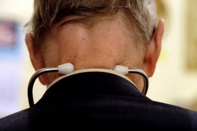 A doctor wears a stethoscope around his neck.