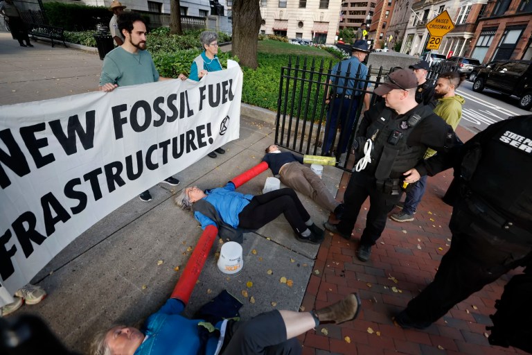 Climate activists from Extinction Rebellion lock themselves to the fence at the entance to the Massachusetts Statehouse during a protest against new fossil fuel infrastructure, Monday, Sept. 23, 2024, in Boston.