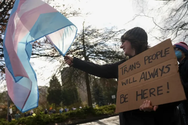 Mariah waves a trans pride flag during a pro-transgender rights protest outside of Seattle Children's Hospital after the institution postponed some gender-affirming surgeries for minors following an executive order by President Donald Trump, Sunday, Feb. 9, 2025, in Seattle. (AP Photo/Lindsey Wasson)