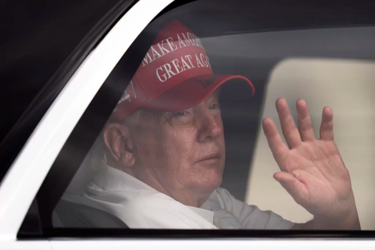 President Donald Trump waves to supporters from his limousine as he arrives at Trump International Golf Club, Saturday, March 29, 2025, in West Palm Beach, Florida.