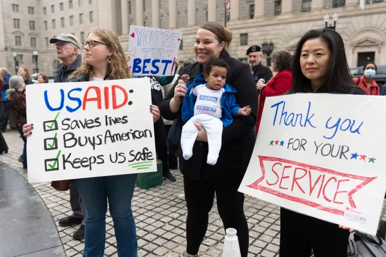 USAID supporters hold banners.
