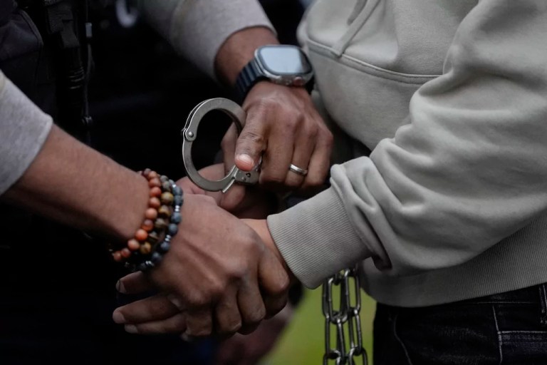 A deportation officer with Enforcement and Removal Operations in U.S. Immigration and Customs Enforcement's New York City field office changes the handcuffs of Wilmer Patricio Medina-Medina