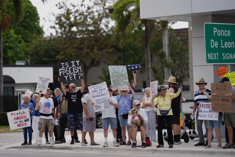 People protest outside a Tesla dealership as part of a coordinated international day of 