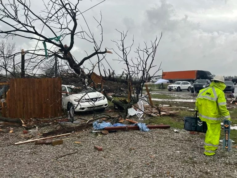 People look over the debris around a home at Lake City, Ark., on Thursday, April 3, 2025.