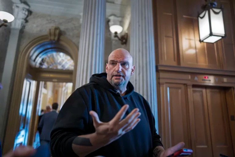 Sen. John Fetterman (D-PA) talks to reporters outside the chamber during a vote, at the Capitol in Washington, Thursday, March 13, 2025.