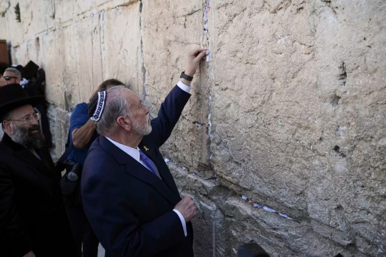 US ambassador to Israel, Mike Huckabee, places a note on behalf of President Donald Trump at the Western Wall, the holiest site where Jews can pray, in the Old City of Jerusalem, Friday, April 18, 2025.
