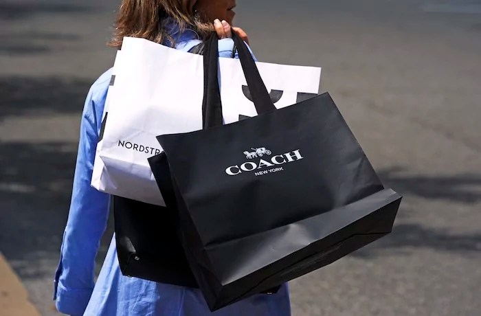 A shopper carries bags in Pittsburgh on Monday, June 3, 2024. On Friday, June 14, 2024