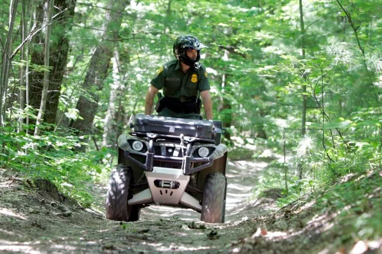 **ADVANCE FOR MONDAY JULY 21**Senior Border Patrol Agent Matthew Hayes rides an all-terrain vehicle through the woods in Swanton, Vt., Wednesday, June 25, 2008. On the northeastern arm of Lake Champlain, it's hard to tell where the U.S.-Canadian border is. There's a small buoy boaters use, but nothing else. This is when the smugglers come _ sometimes in rented boats, to a waiting getaway car on shore, sometimes walking across the border on railroad tracks, or through dense northern Vermont woods. A beefed-up law enforcement presence along the border is making a difference this year. The U.S. Border Patrol is seeing fewer organized smuggling efforts. (AP Photo/Toby Talbot)