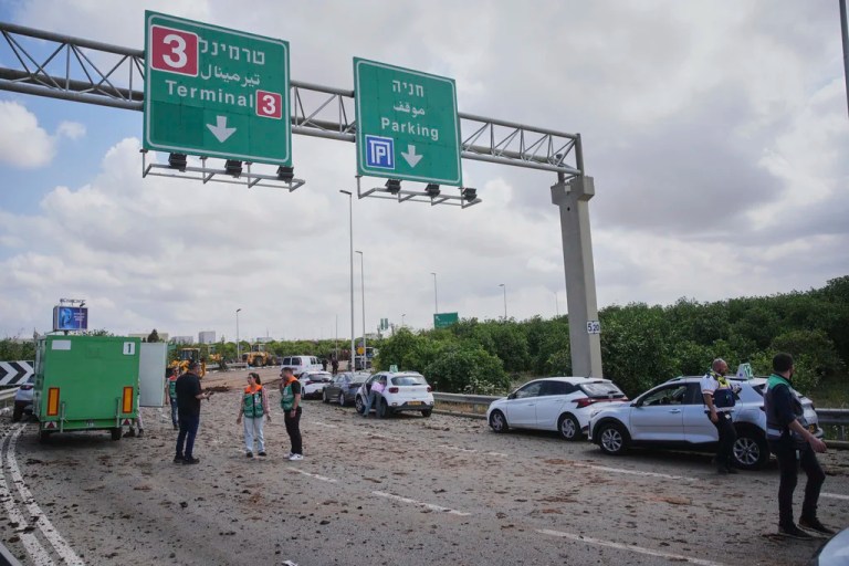 Israeli security forces inspect the site where the Israeli military said a projectile fired by Yemen's Houthi rebels landed in the area of Ben Gurion International Airport near Tel Aviv, Israel