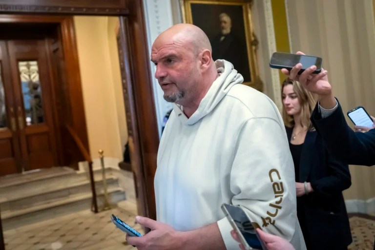 Sen. John Fetterman (D-PA) speaks to reporters as he walks near the Senate chamber at the Capitol in Washington, Friday, March 14, 2025.
