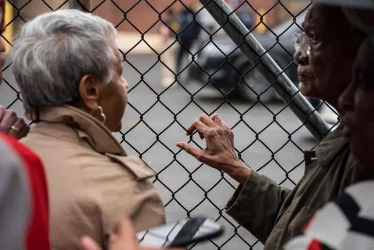 Amina Baraka, right, mother of Newark Mayor Ras J. Baraka, puts her hand on the fence of the Immigration and Customs Enforcement office where her son is being held after he was arrested while protesting outside an ICE detention facility, Friday, May 9, 2025, in Newark, New Jersey.