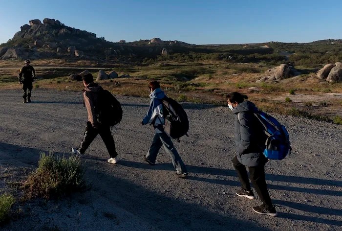 Chinese migrants follow a U.S Border Patrol agent to be processed after crossing the border with Mexico Wednesday, May 8, 2024, near Jacumba Hot Springs, Calif. San Diego became the busiest corridor for illegal crossings in April, according to U.S. figures, the fifth region to hold that title in two years in a sign of how quickly migration routes are changing. (AP Photo/Ryan Sun)