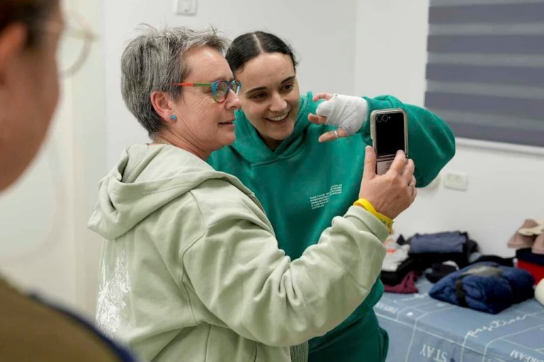 In this photo released by the Israeli Army, Emily Damari, right, and her mother Mandy use a smart phone near kibbutz Reim, southern Israel, after Emily was released from captivity by Hamas militants in Gaza, Sunday, Jan. 19, 2025.