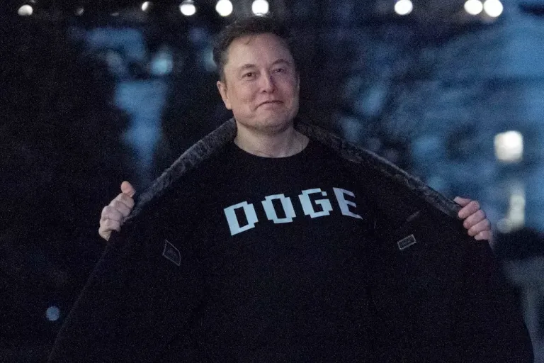 Elon Musk flashes his T-shirt that reads 