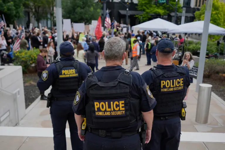 Department of Homeland Security officers stand as protesters gather outside the Federal Courthouse before arguments whether Kilmar Abrego Garcia can be released from jail on Friday, June 13, 2025 in Nashville, Tennessee.