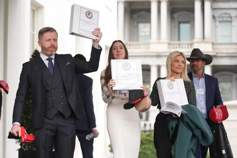 Conservative political commentator Rogan O'Handley, also known as DC Draino, from left, social media content creator Chaya Raichik and conservative political commentator Liz Wheeler hold up binders with a cover titled 