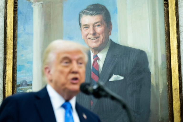 With a painting of President Ronald Reagan behind him, President Donald Trump speaks during a swearing in ceremony for Alina Habba as interim US Attorney General for New Jersey, in the Oval Office of the White House in Washington, Friday, March 28, 2025.