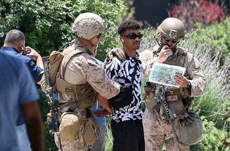 U.S. Marines detain a person outside the Wilshire Federal Building after Marines were deployed to Los Angeles, as protests against federal immigration sweeps continue, in Los Angeles, California, June 13, 2025.