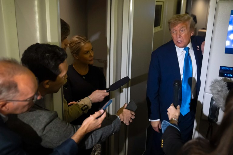 President Donald Trump speaks with reporters as White House press secretary Karoline Leavitt listens while flying aboard Air Force One en route from Calgary, Canada to Joint Base Andrews, Maryland, late Monday, June 16, 2025.