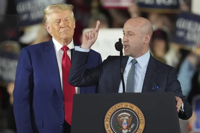 President Donald Trump listens as White House deputy chief of staff for policy Stephen Miller speaks on his first 100 days at Macomb County Community College Sports Expo Center, Tuesday, April 29, 2025, in Warren, Mich.