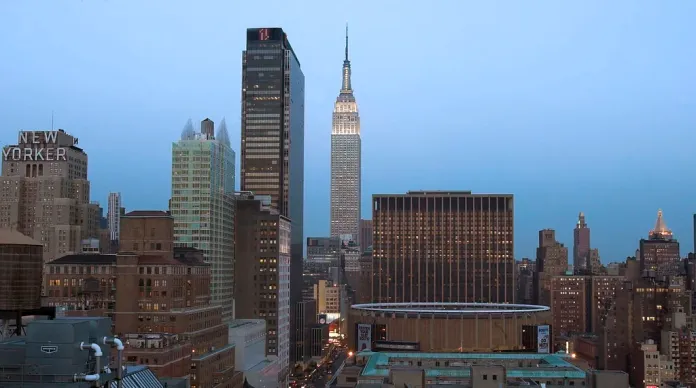 Two people climb to top of Empire State Building with flag