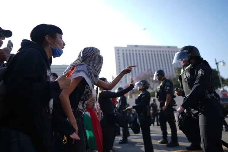 Protesters confront LA Police Department personnel in riot gear in downtown Los Angeles on Monday, June 9, 2025.
