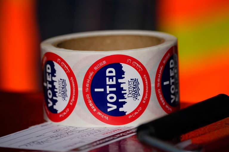 Stickers for voters sit in a roll on top of a ballot box at a voting drop-off location, Oct. 25, 2024, in Washington Park in Denver.