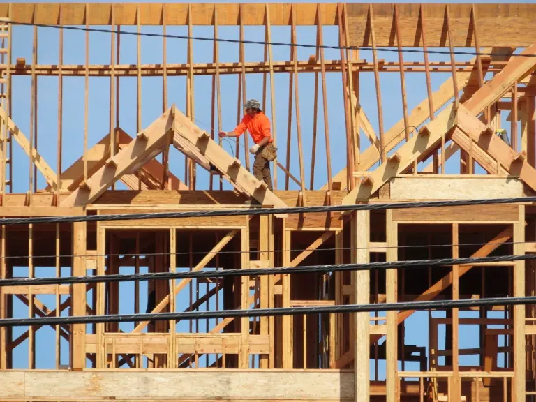 A construction worker examines part of a building under construction.