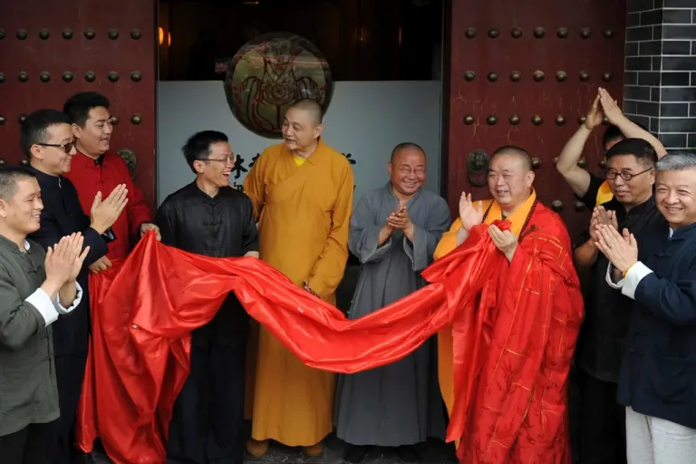 In this photo taken Sunday June 28, 2015, Shi Yongxin, third from right in yellow and red robes, abbot of the Shaolin Temple, attends the opening ceremony of an urban zen center named Shaolin Chan Hall in Xi'an in northwest China's Shaanxi province.