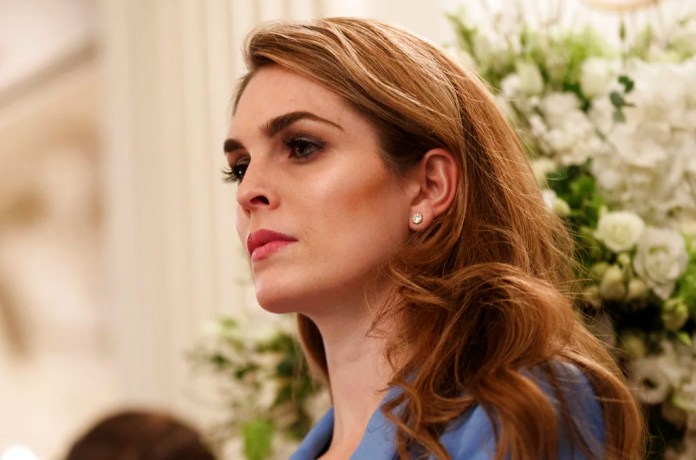 White House communications director Hope Hicks, stands in the back of the room as President Donald Trump hosts a listening session with high school students and teachers in the State Dining Room of the White House in Washington, Wednesday, Feb. 21, 2018.