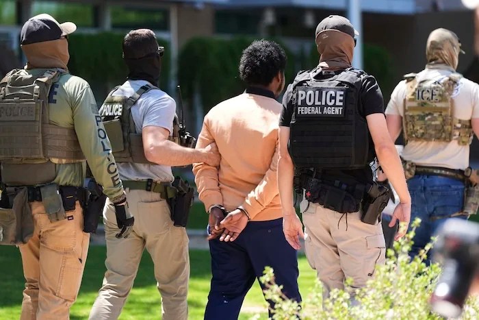 Federal agents takes a person into custody after an immigration court hearing outside an immigration court, Wednesday, May 21, 2025, in Phoenix. (AP Photo/Ross D. Franklin)