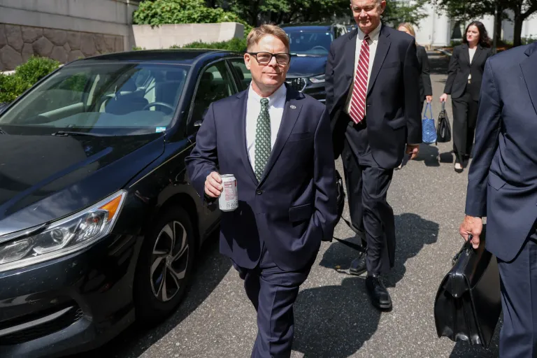 Dr. Kevin O'Connor walks in front of cars.