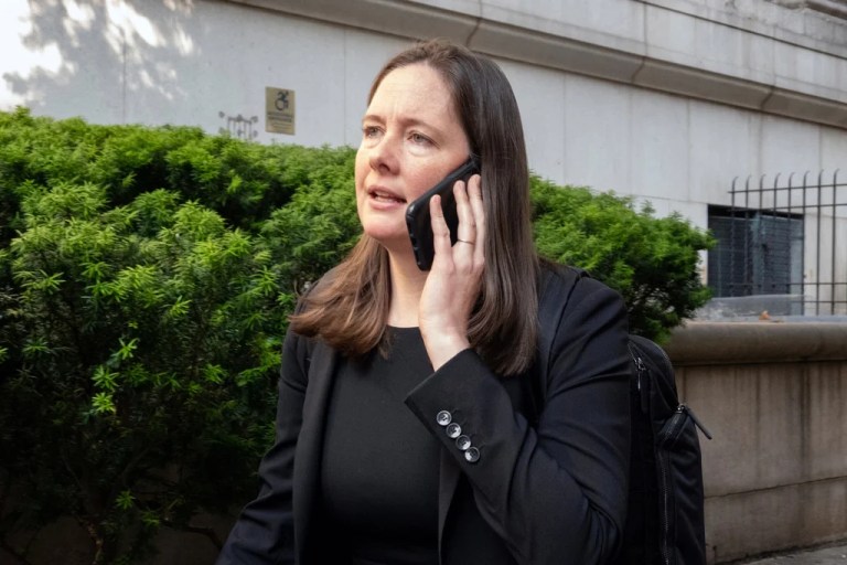 Assistant U.S. Attorney Maurene Comey talks on the phone outside.