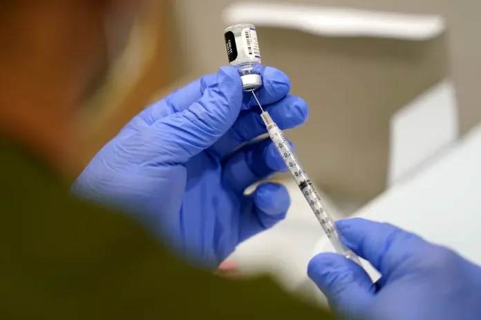 FILE - A healthcare worker fills a syringe with the Pfizer COVID-19 vaccine at Jackson Memorial Hospital on Oct. 5, 2021, in Miami. (AP Photo/Lynne Sladky, File)