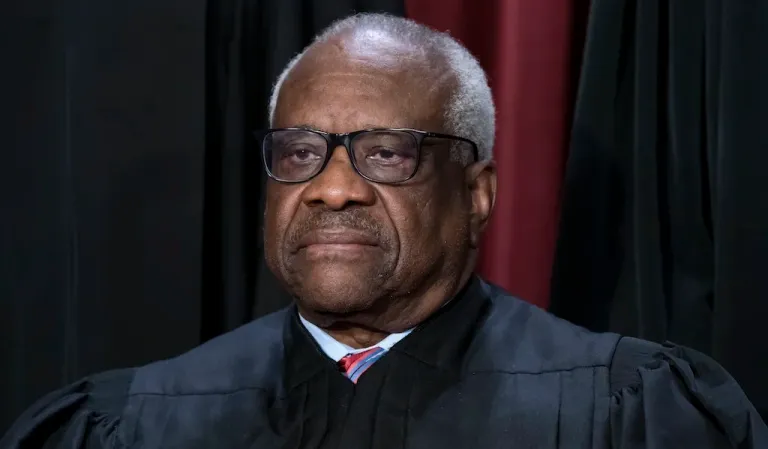 Associate Justice Clarence Thomas joins other members of the Supreme Court as they pose for a new group portrait, at the Supreme Court building in Washington, Oct. 7, 2022. Thomas is absent from the court Monday with no explanation. The 75-year-old Thomas also is not participating remotely in arguments, as justices sometimes do when they are ill or otherwise can’t be there in person. Chief Justice John Roberts announced Thomas’ absence, saying that his colleague would still participate in the day’s cases, based on the briefs and the transcripts of the arguments.
