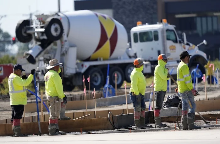 Jobs report - Construction crew members wait to pour concrete in a parking lot on Sept. 4, 2024, in Waukee, Iowa