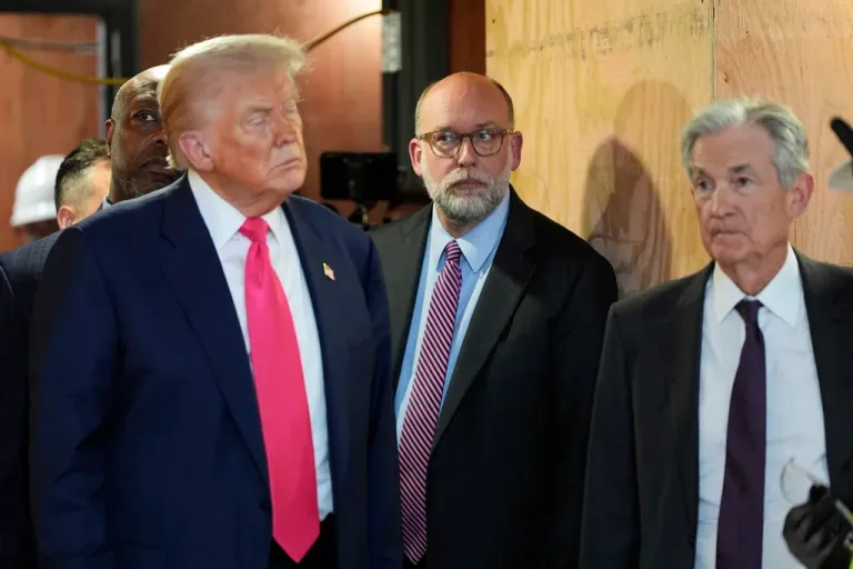 Office of Management and Budget Director Russell Vought, President Donald Trump, and Federal Reserve Chairman Jerome Powell stand next to one another.