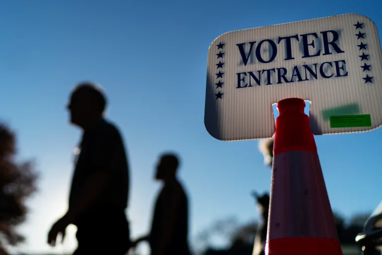 Voters pass a sign outside a polling site.