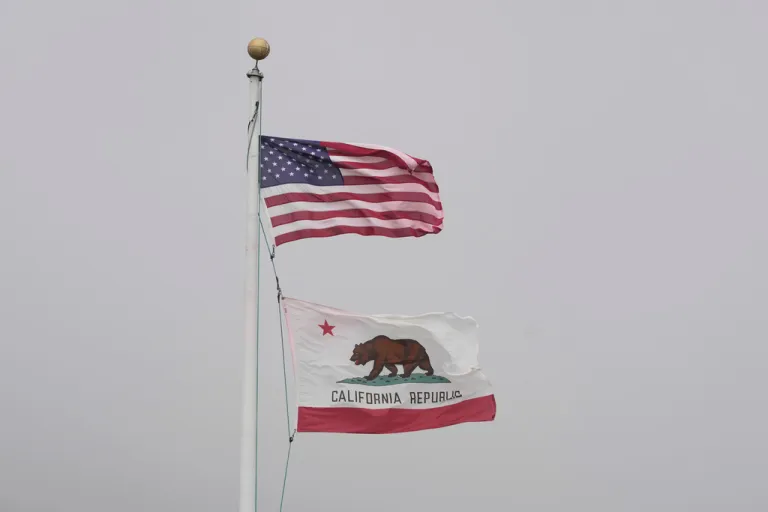 Flags of the United States of America, top, and state of California fly at the Golden Gate Bridge Vista Point in Sausalito, California, Wednesday, July 2, 2025.