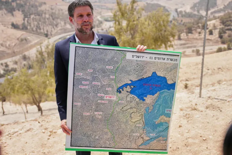 Israeli Finance Minister Bezalel Smotrich holds a map of the E1 settlement project.