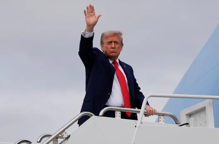 President Donald Trump waves as he boards Air Force One after meeting with Russia's President Vladimir Putin