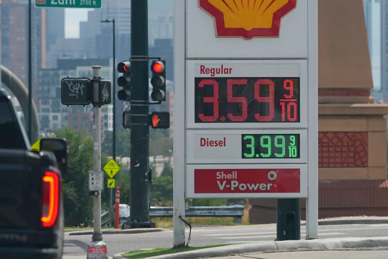 As a motorist brakes for a red light, an electronic sign displays the per-gallon price for regular gasoline at a Shell station, Tuesday, Aug. 26, 2025, near downtown Denver.