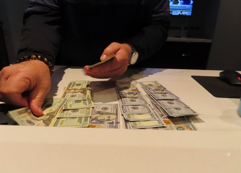 A worker at the Sportsbook in the Ocean Casino Resort counts money on a counter