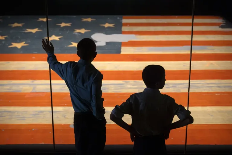 Children look at the Star Spangled Banner, the flag that inspired the lyrics of the American national anthem, at the Smithsonian's National Museum of American History, Tuesday, June 10, 2025, in Washington. (AP Photo/Mark Schiefelbein)