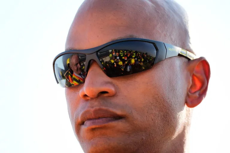 Members of the press are reflected in safety glasses worn by Maryland Gov. Wes Moore (D) during a press conference after a tour of the demolition work zone for the remaining portions of the Francis Scott Key Bridge, Wednesday, July 30, 2025, in Baltimore.
