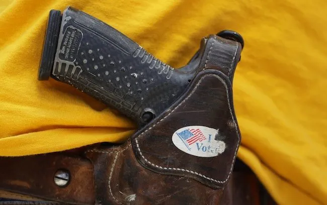 In this April 14, 2018 file photo, a man wears an unloaded pistol during a pro gun-rights rally in Austin, Texas.